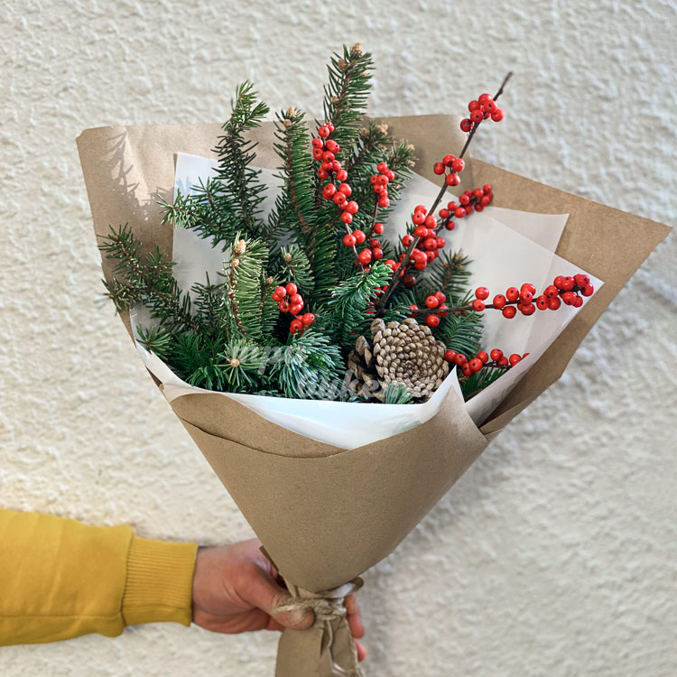 Зимний букет из ягод и веток хвои (на фоне стены)